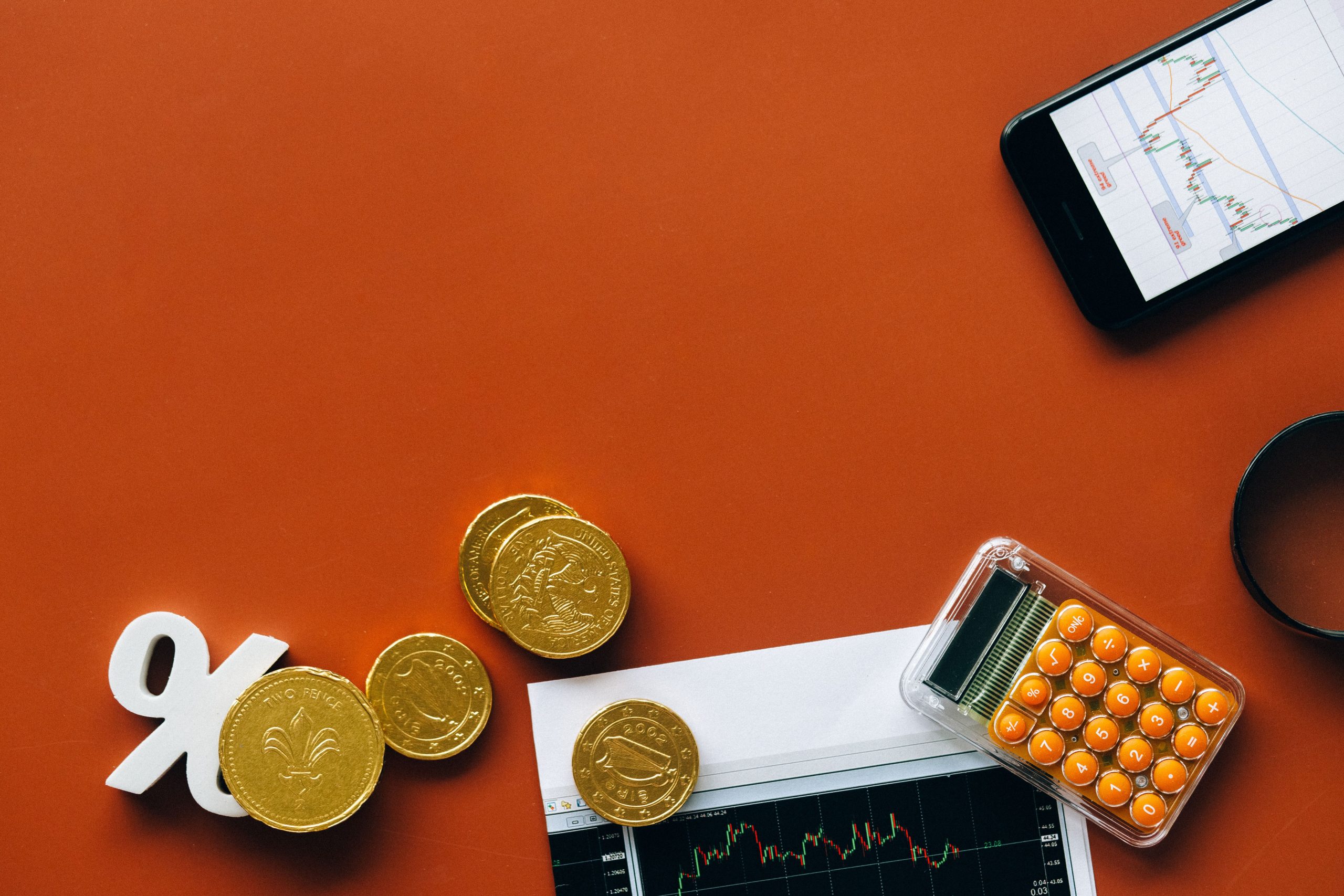 Pièces monnaie calculatrice graphiques fond rouge analyse financière