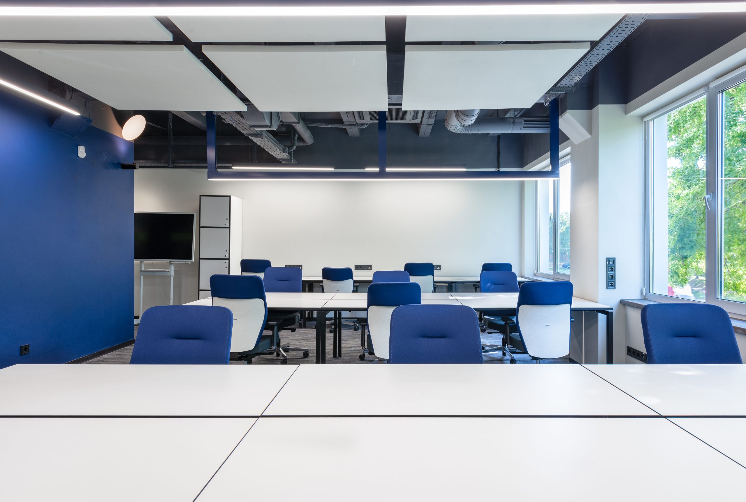 Bureaux blancs et chaises bleues en open space