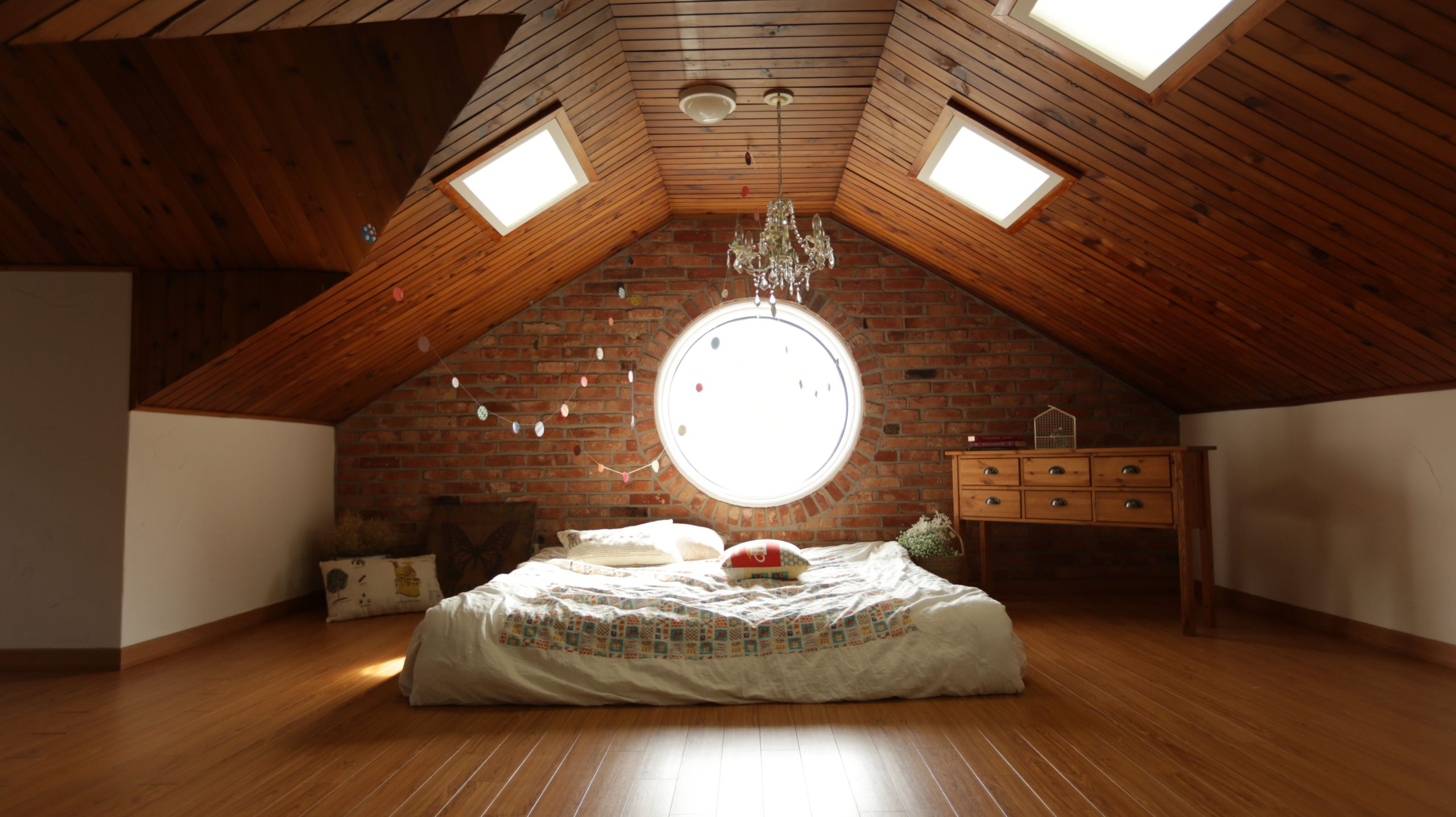 Chambre mansardée design avec mur brique