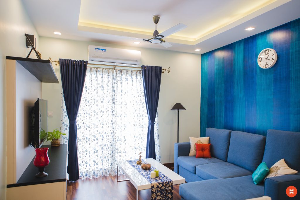 Salon moderne avec canapé bleu et lumière naturelle