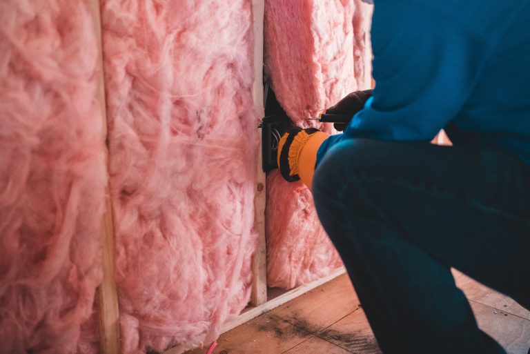 Ouvrier isolant mur avec laine de roche rose