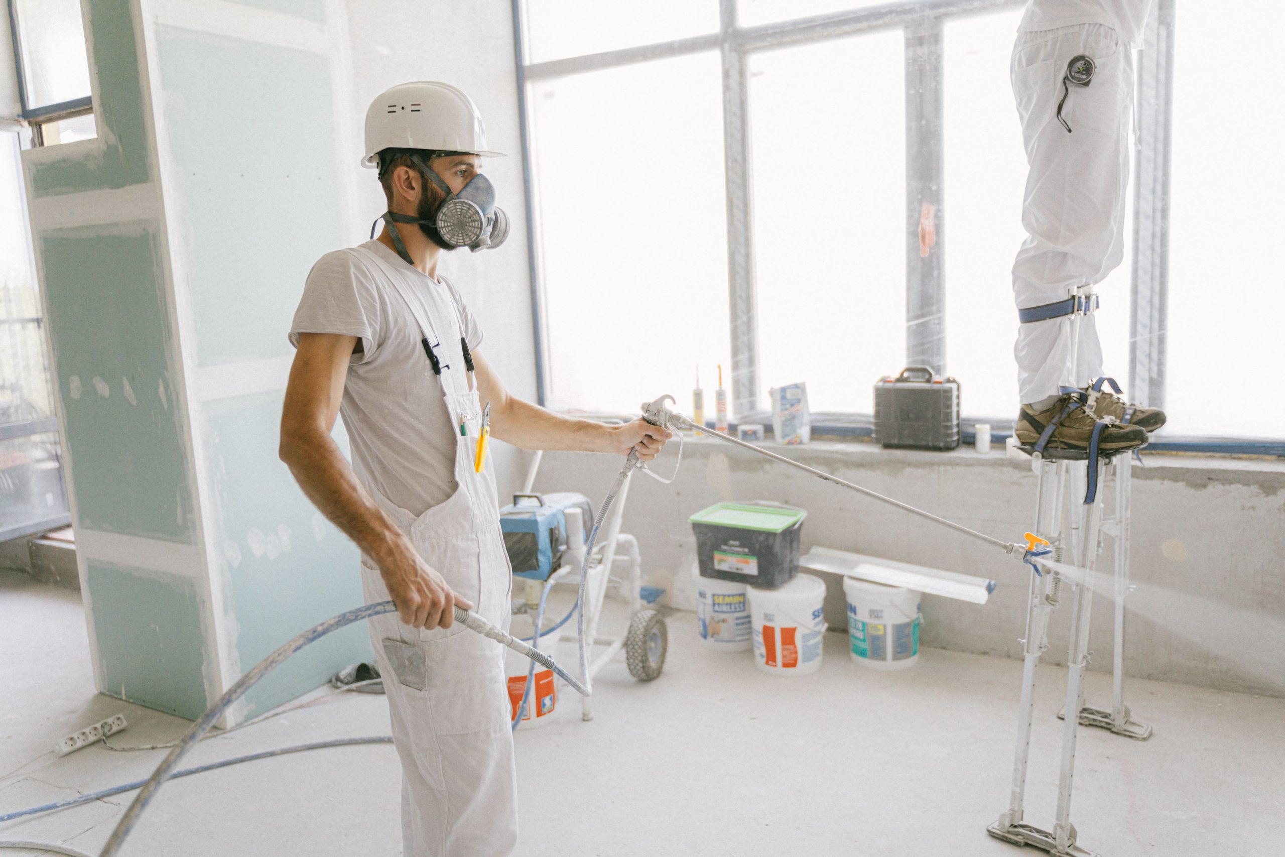 Deux ouvriers peignent intérieur maison rénovation