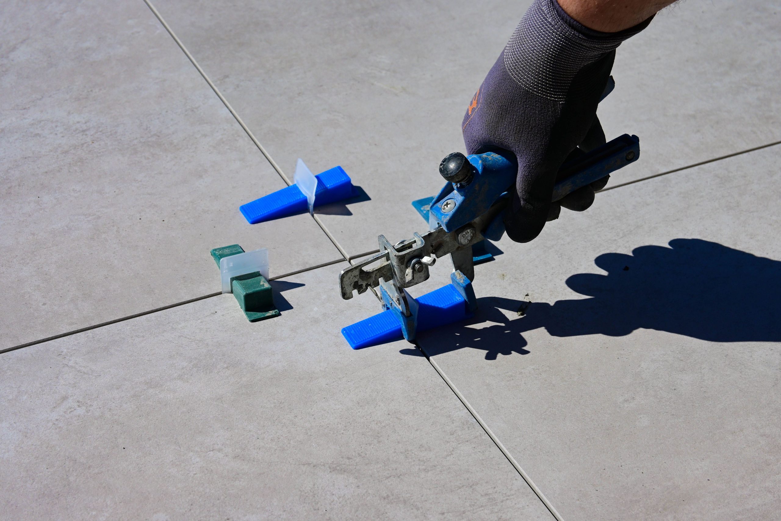 Pose carrelage avec espaceurs et outil nivellement
