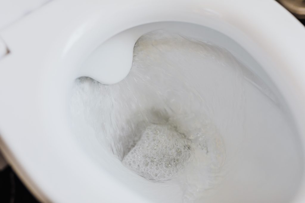 Cuvette de toilette blanche avec eau qui coule
