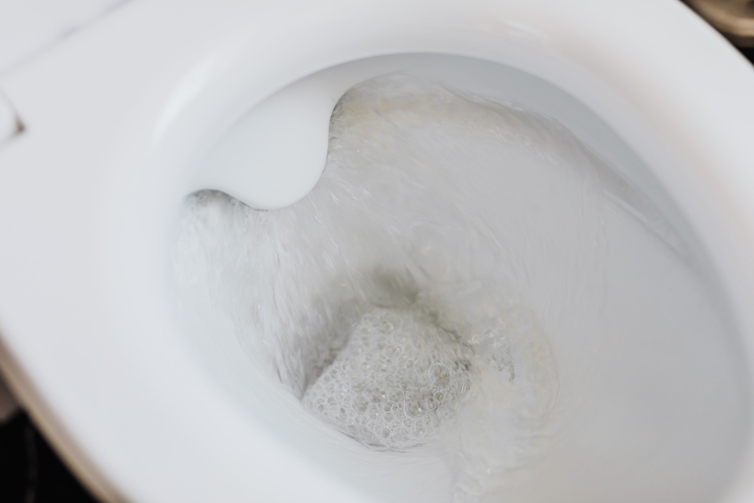 Cuvette de toilette blanche avec eau qui coule