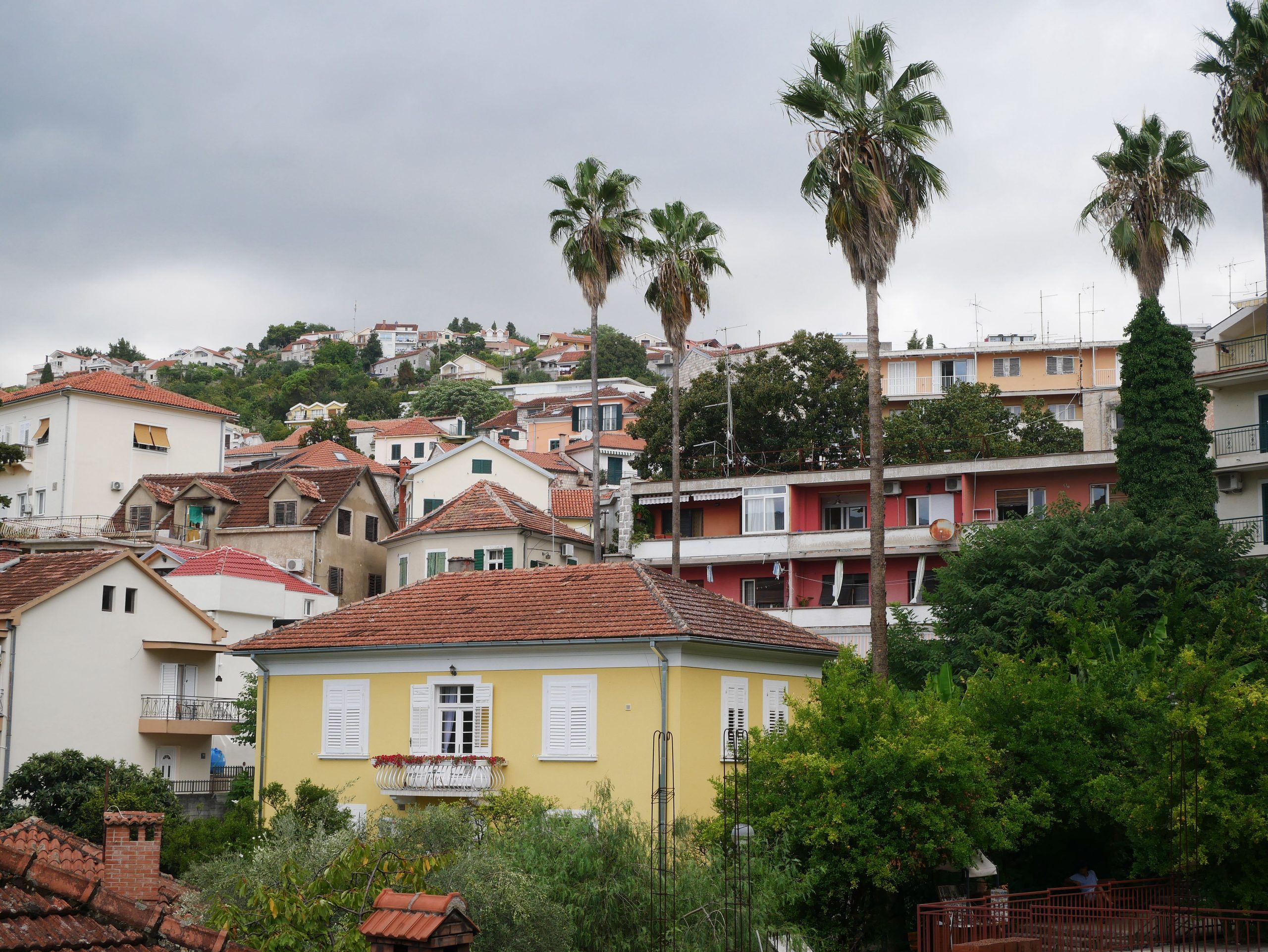 Village méditerranéen coloré sur colline avec palmiers