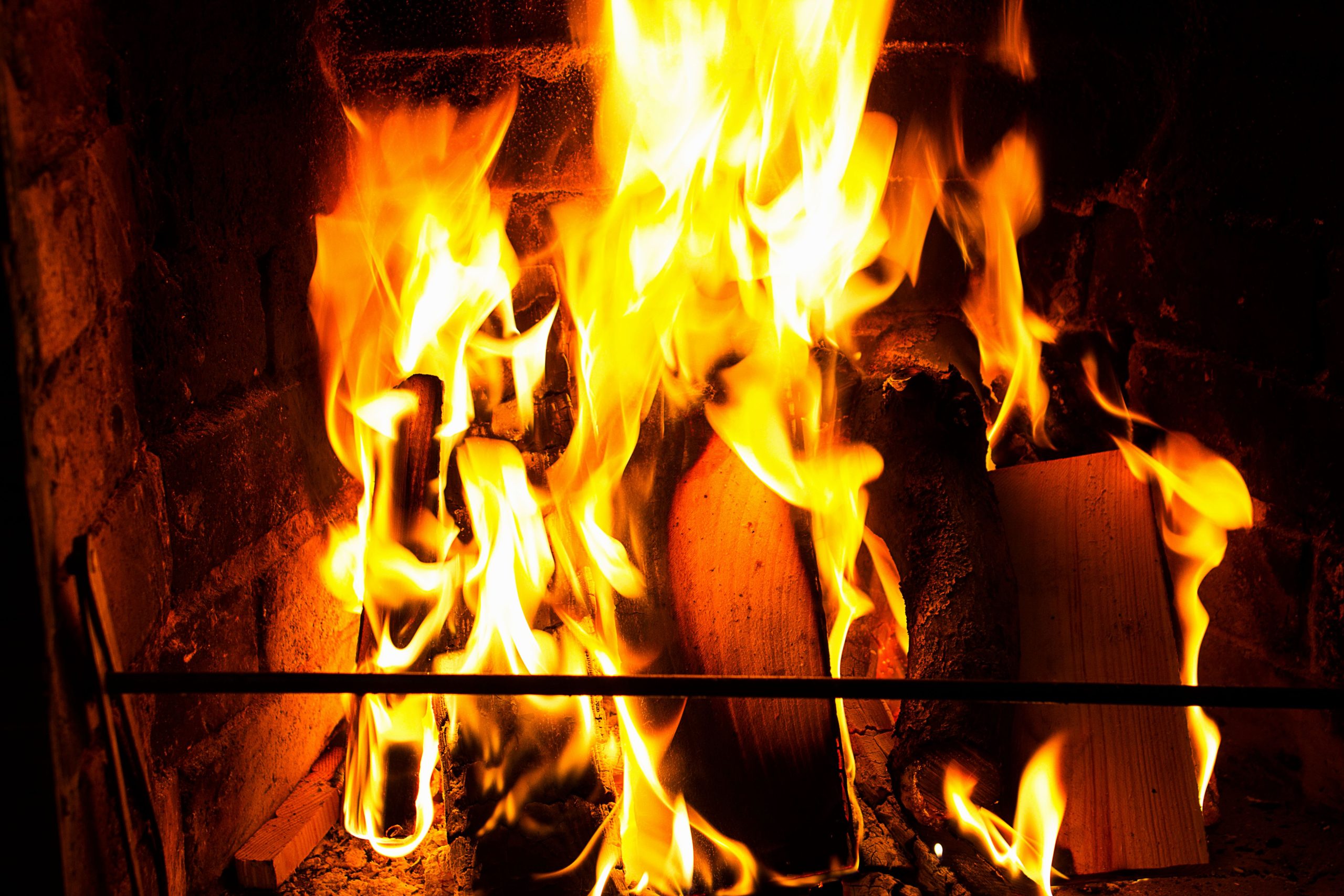 Flammes vives consumant bois dans cheminée brique