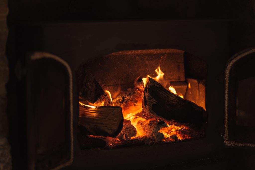 Bois qui brûle dans cheminée avec flammes orangées