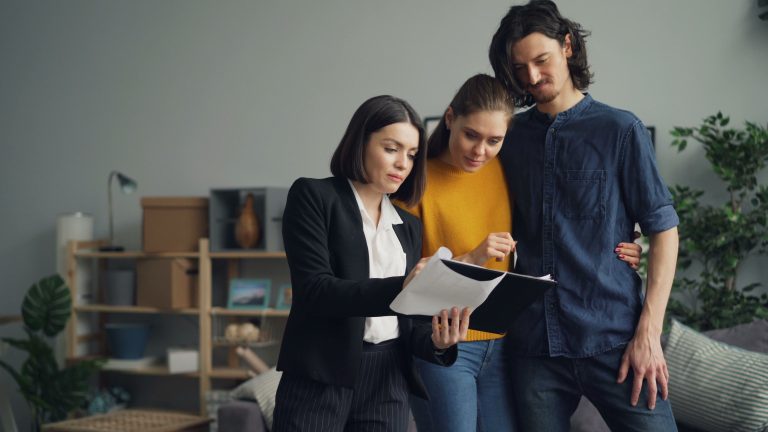 Couple consultant un agent immobilier sur propriete