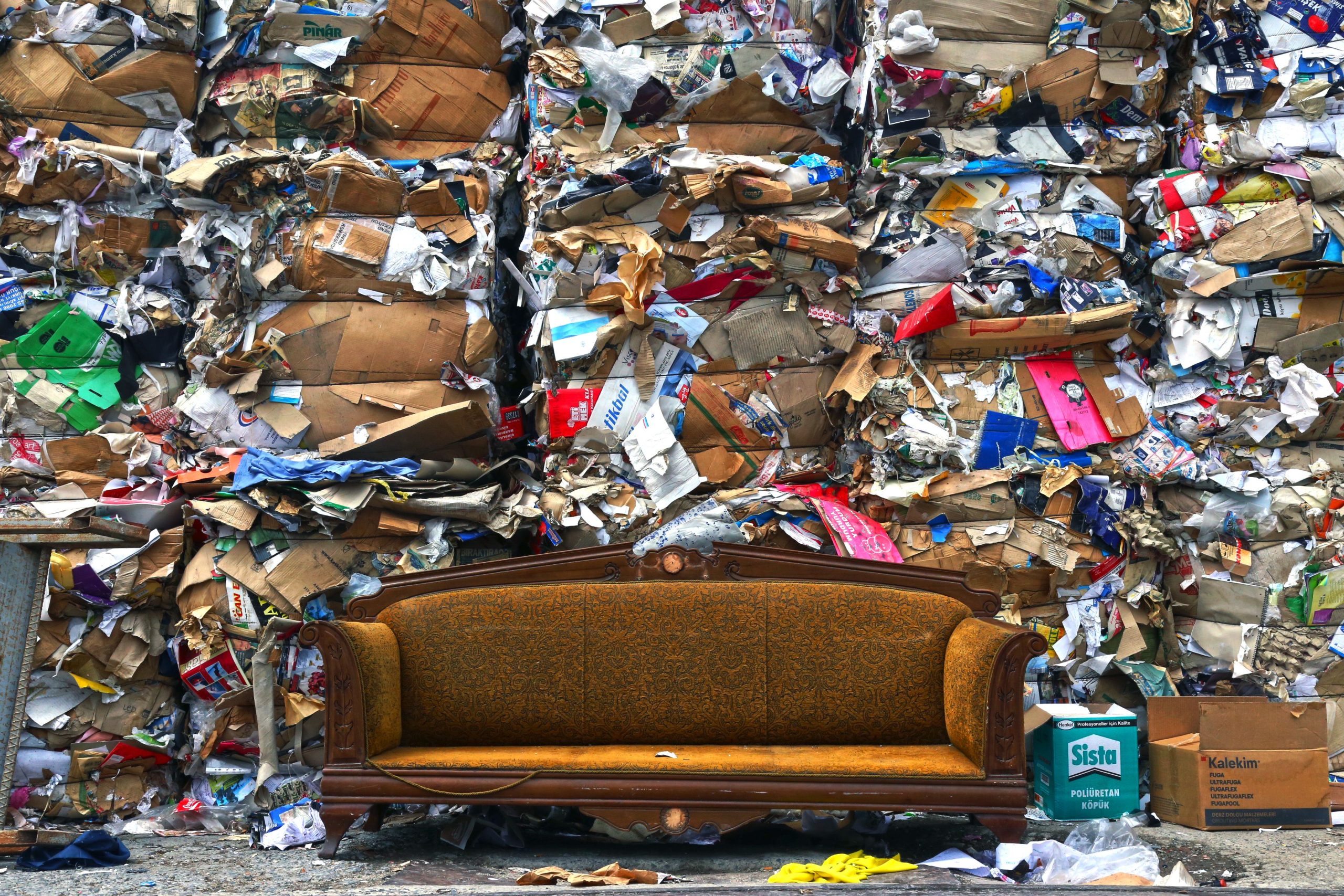 Vieux canapé devant des déchets de carton compressé