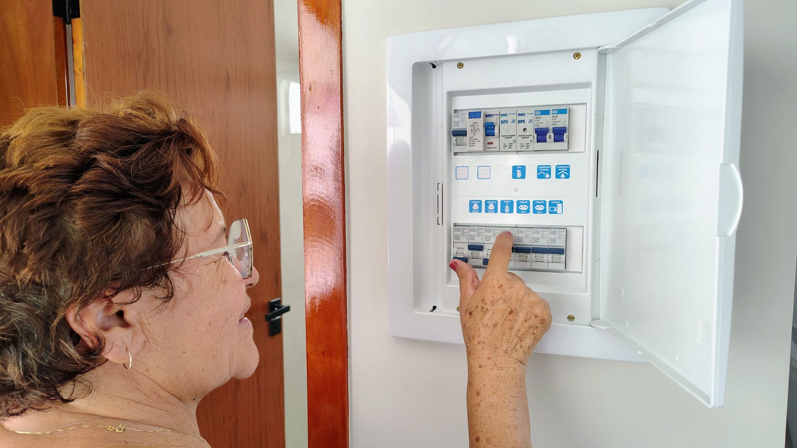 Femme ajuste un panneau électrique maison
