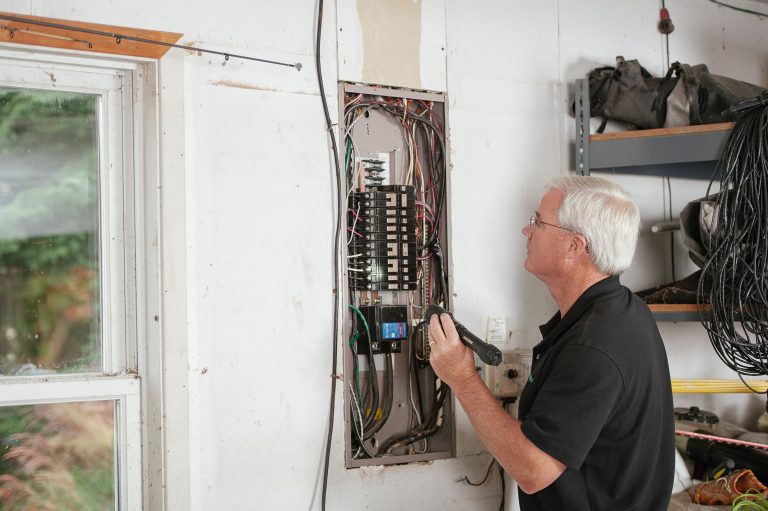 Électricien examine un disjoncteur résidentiel