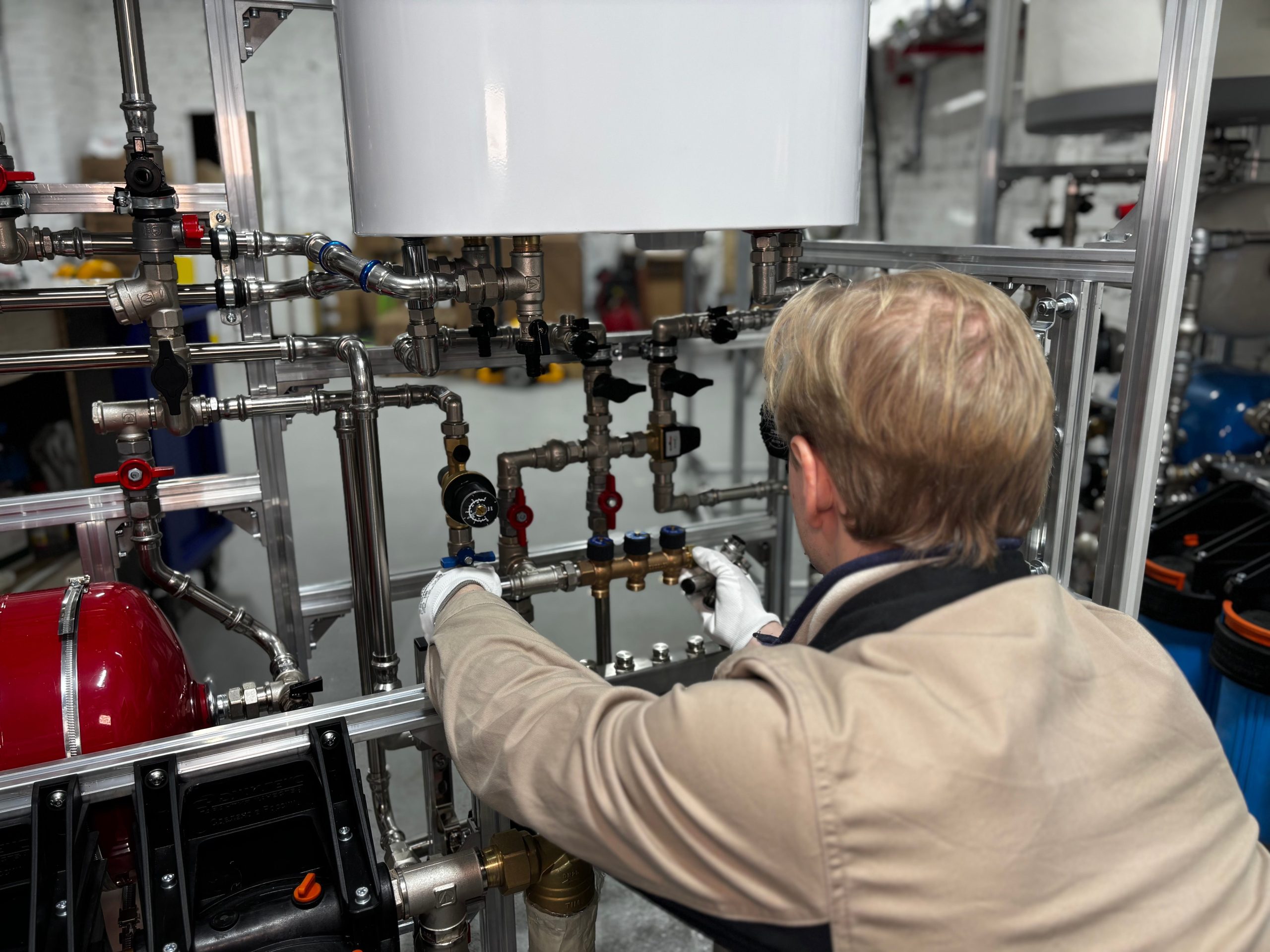 Technicien réglant système chauffage industriel tuyauterie