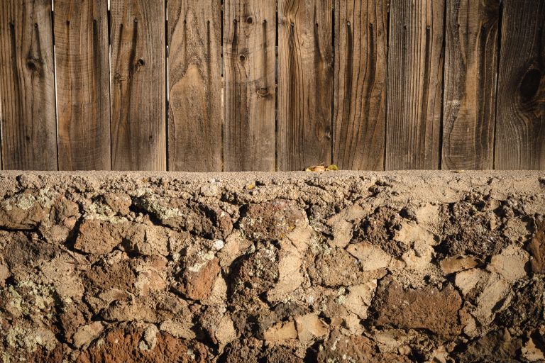 Cloture bois rustique sur mur pierre texturee