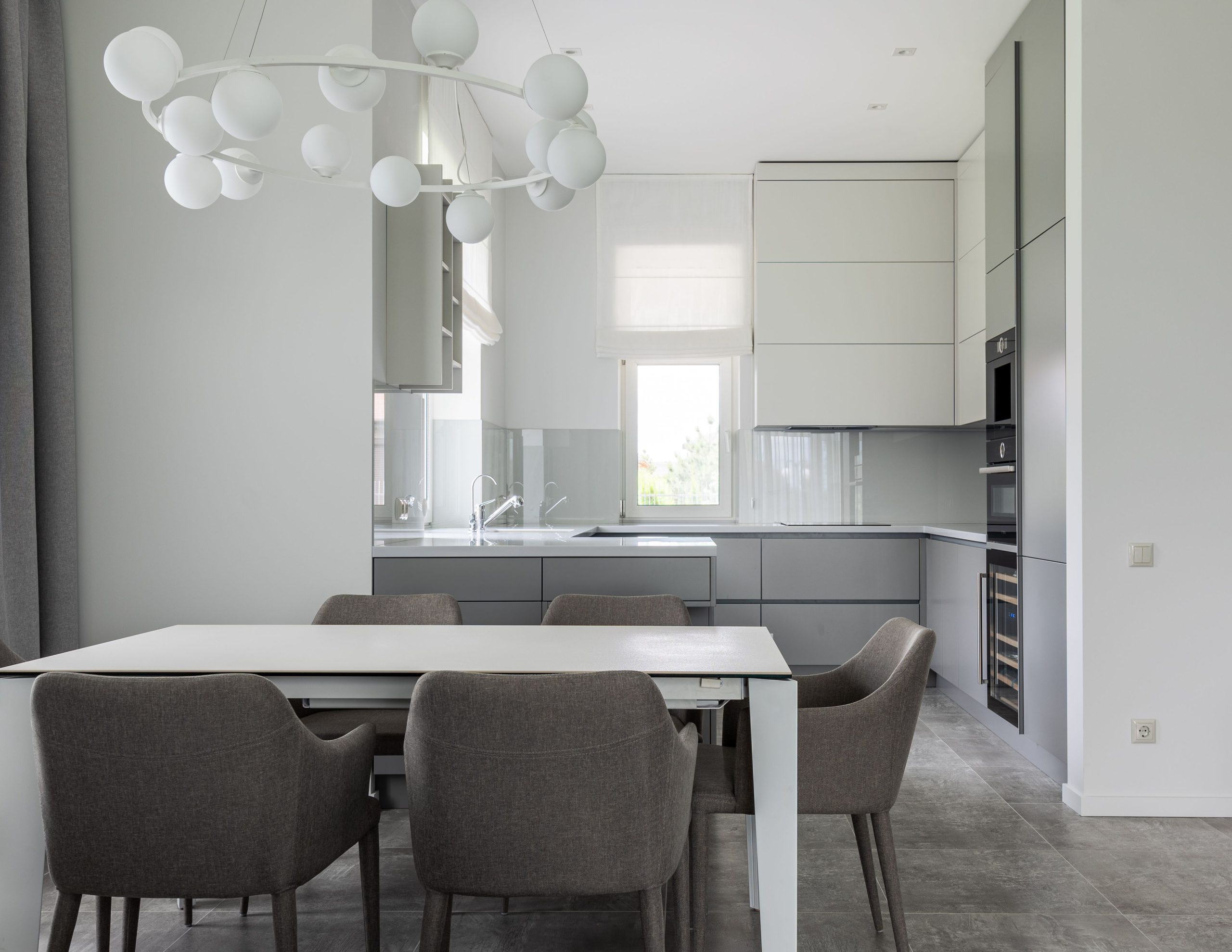 Cuisine contemporaine avec table blanche et chaises grises