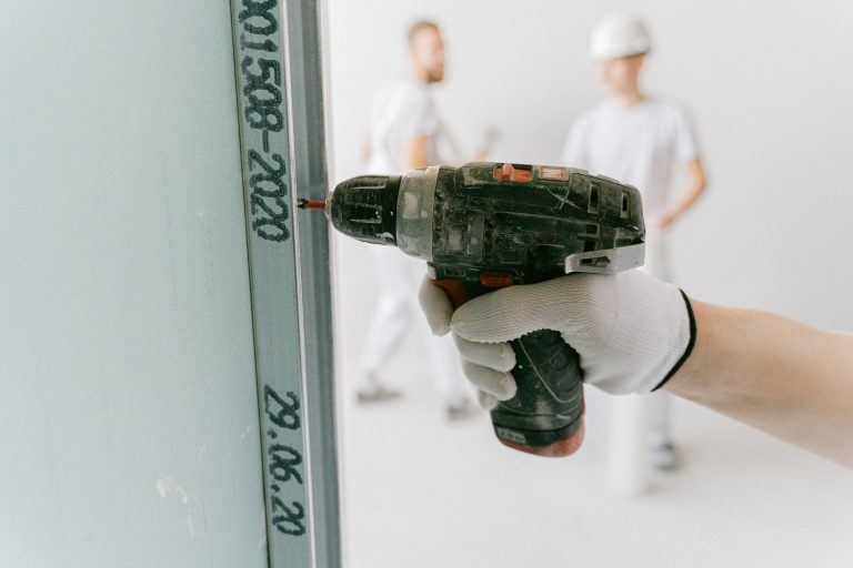 Ouvrier visser placo avec perceuse professionnelle