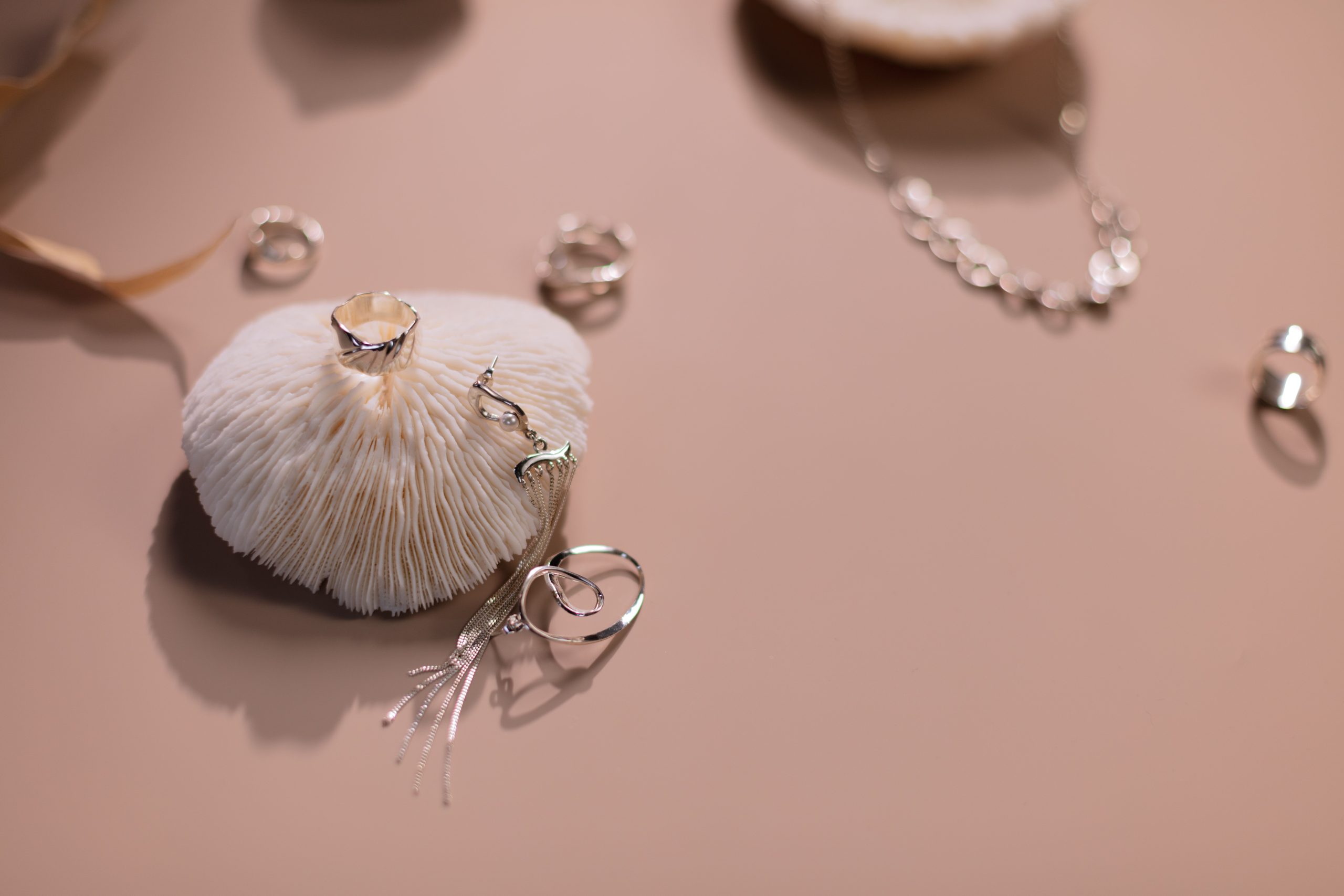 Bijoux argent elegants sur fond rose