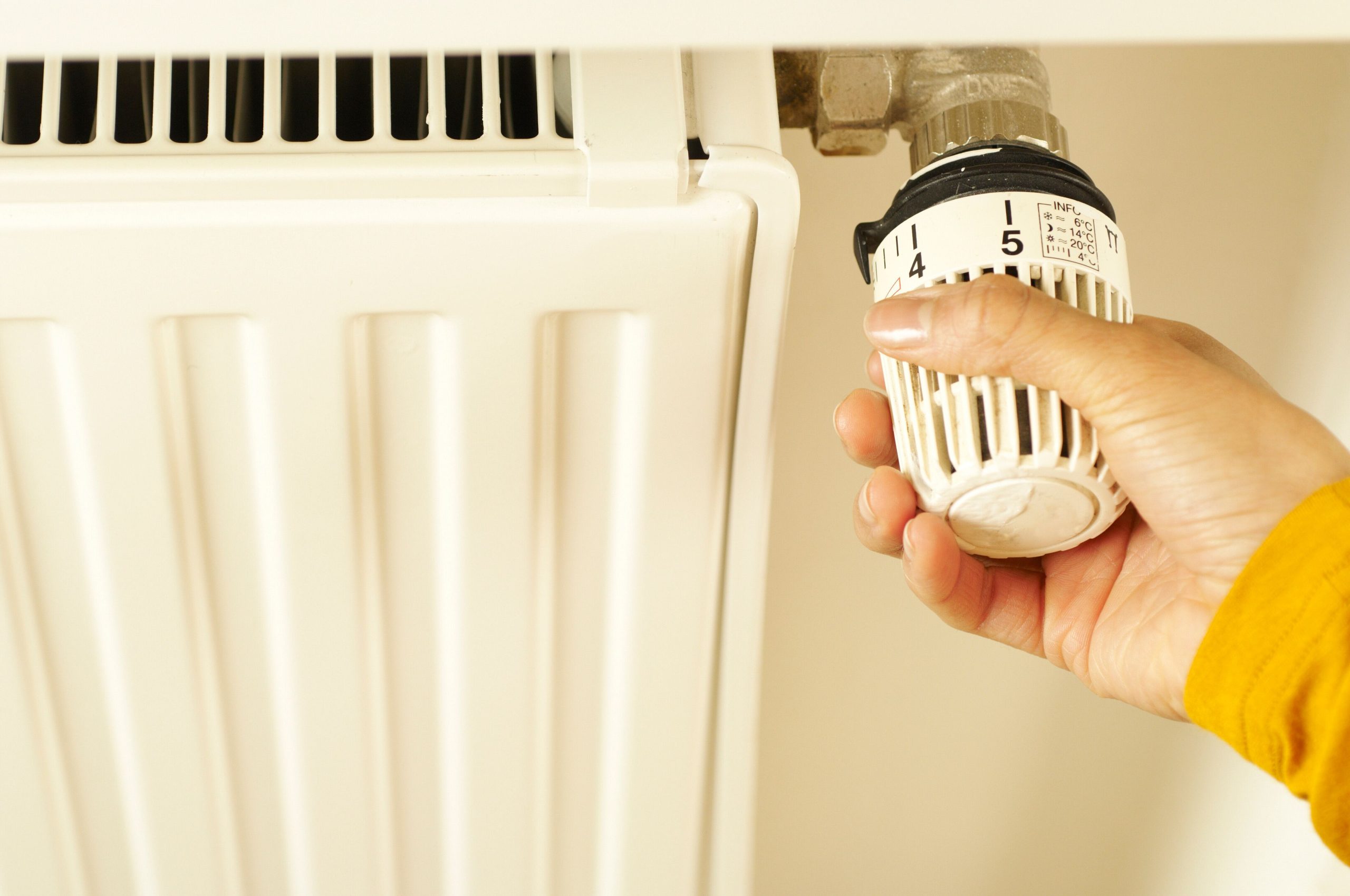 Main ajustant le thermostat du radiateur